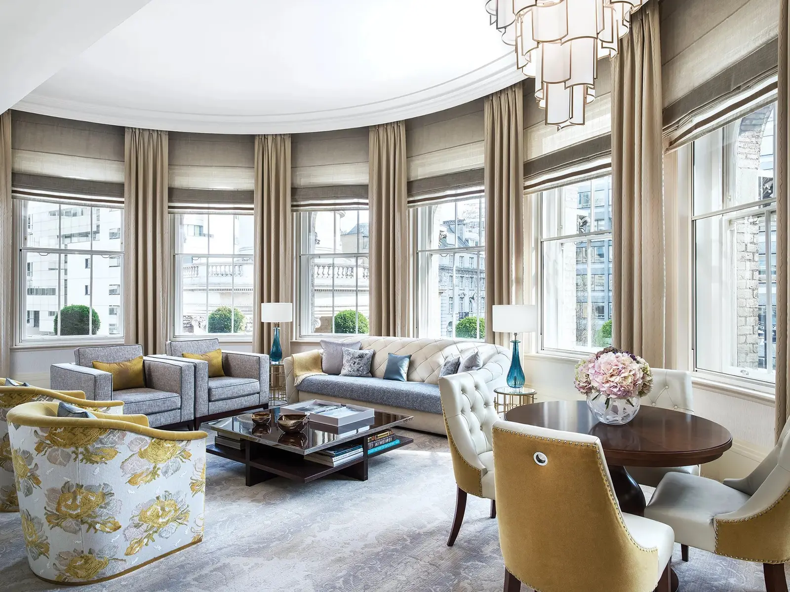 The Infinity Suite’s semicircular sitting room: bay windows, yellow armchairs and a dining table