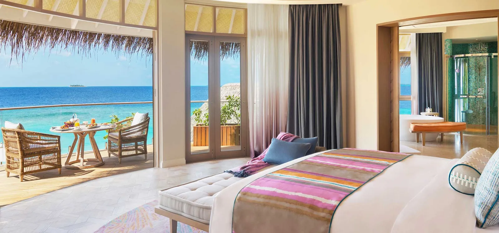 The bedroom with doors opening towards the sea.