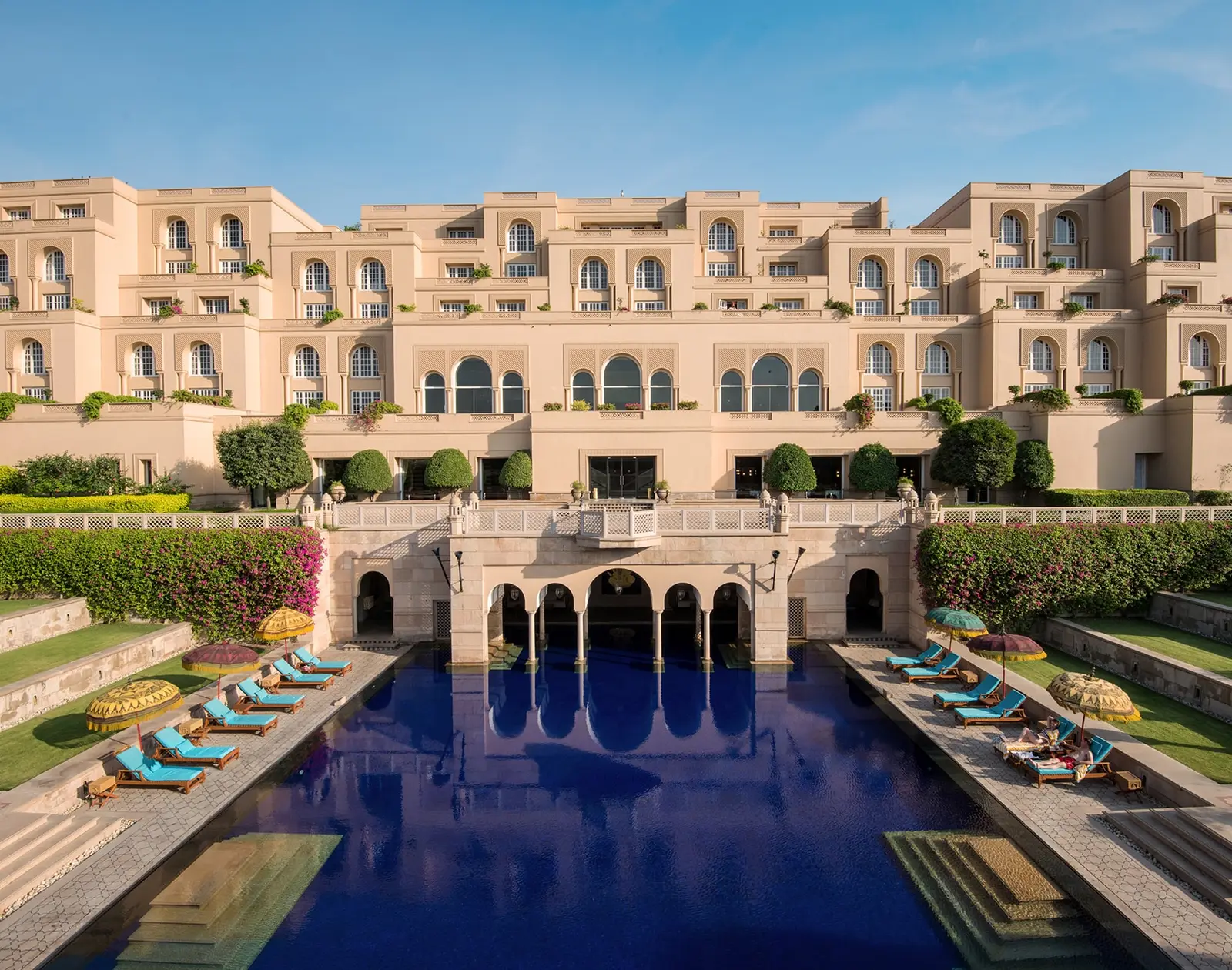 The long pool between the terraces, with turquoise loungers and the hotel’s façade behind
