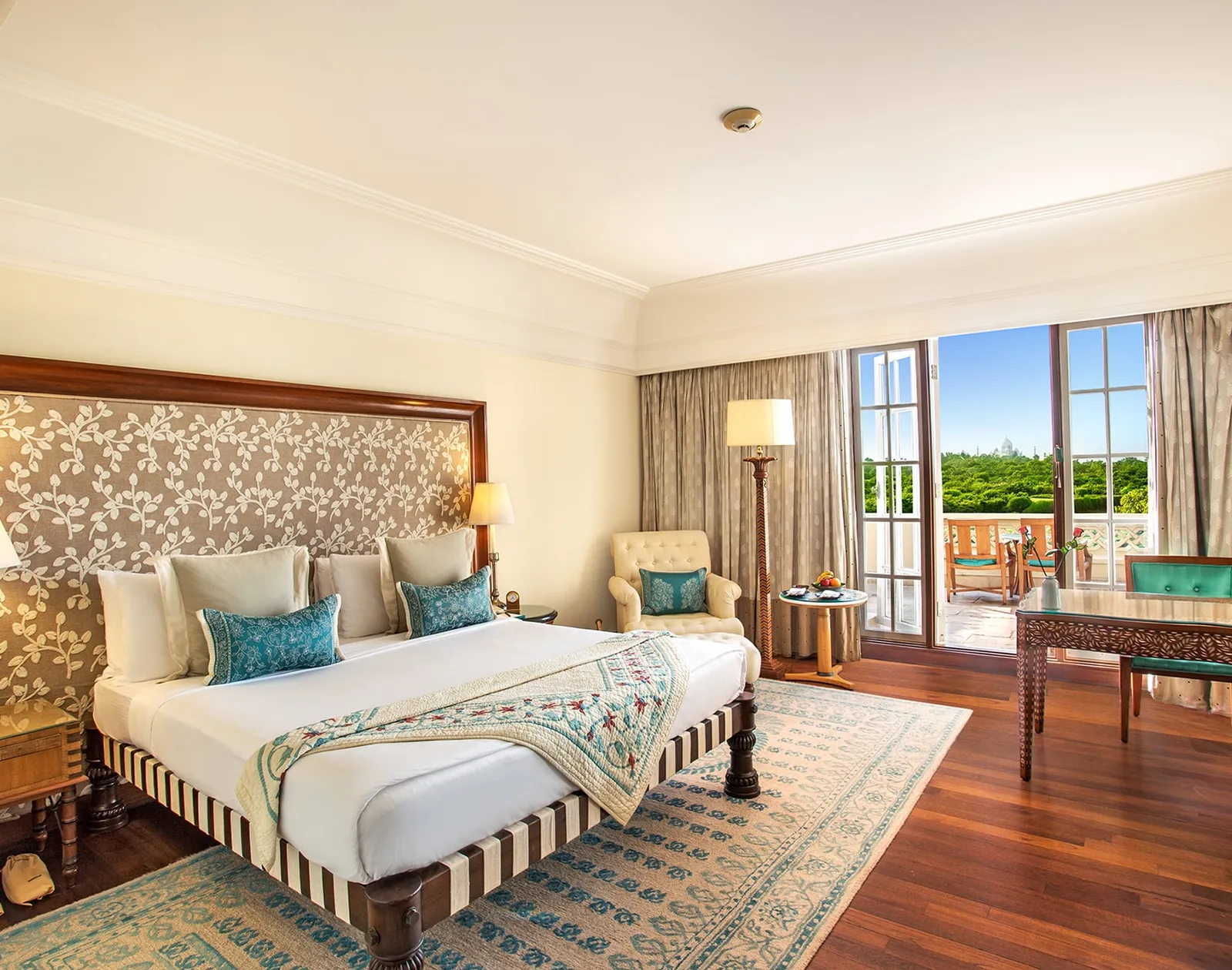 A Premier Room with Balcony, its king bed and the French window open onto the balcony