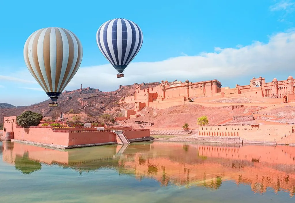 2 hot-air balloons above Amber Fort and the lake below it