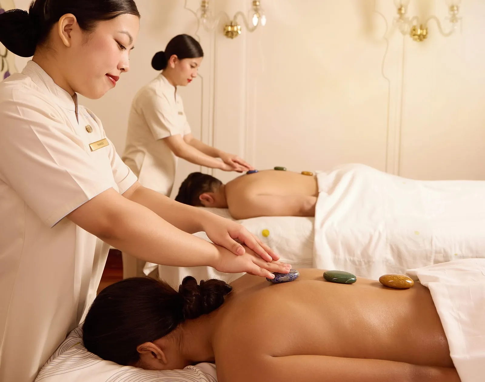 2 guests lying on spa beds during a hot-stone massage