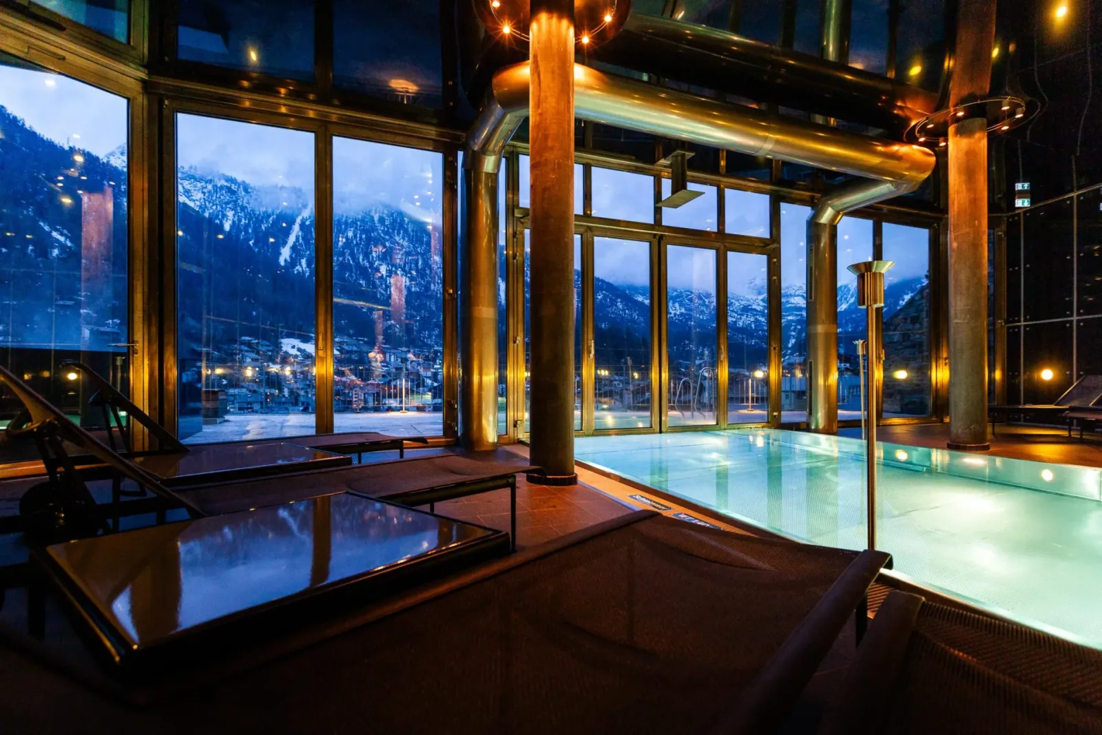 The pool with mountain-facing windows and loungers