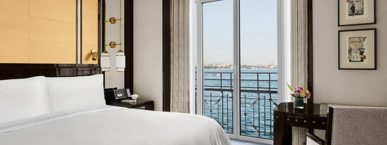 A Superior Bosphorus Room: the king bed and the open French window with its iron rail, the Bosphorus just outside and 2 framed prints on the wall.