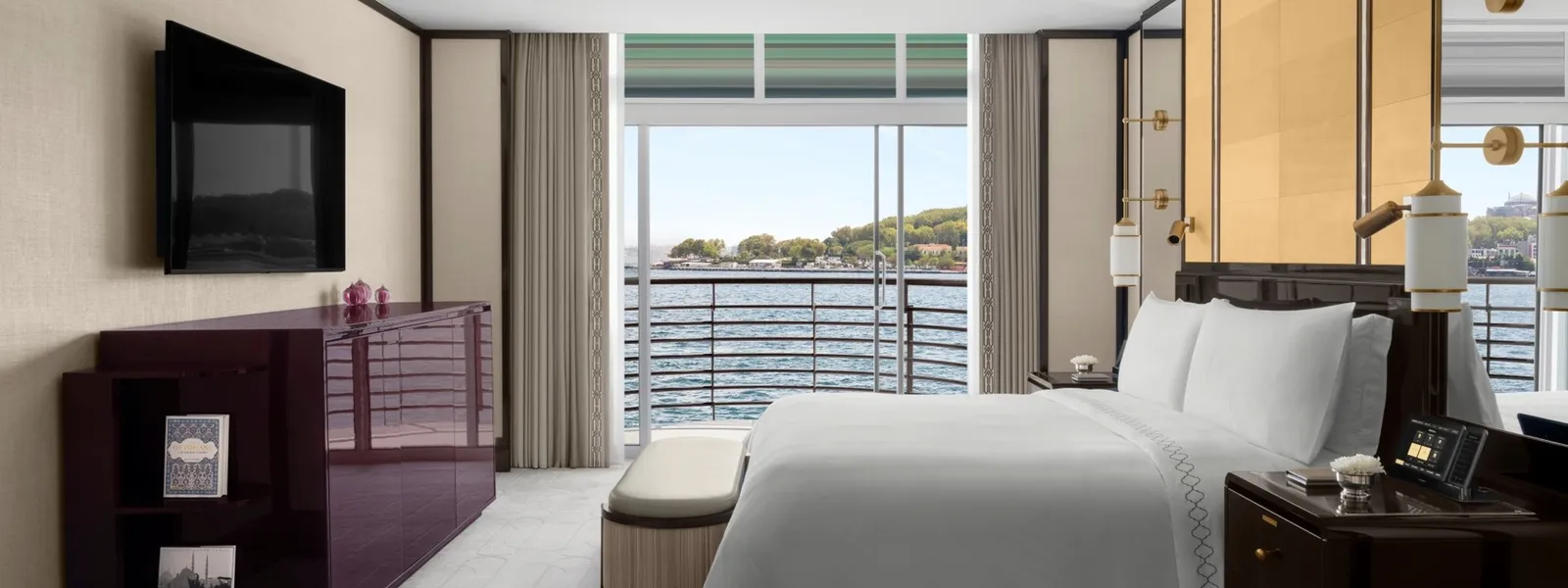 A Superior Bosphorus Suite bedroom: the king bed before the sliding window, with the small balcony, the Bosphorus and the wooded headland opposite.