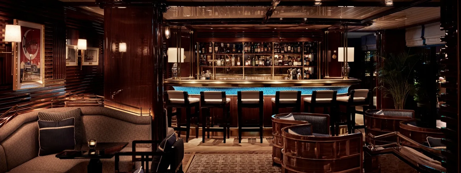 Topside Bar: the lit counter with its stools, walls of dark polished wood, tub chairs and a corner banquette.