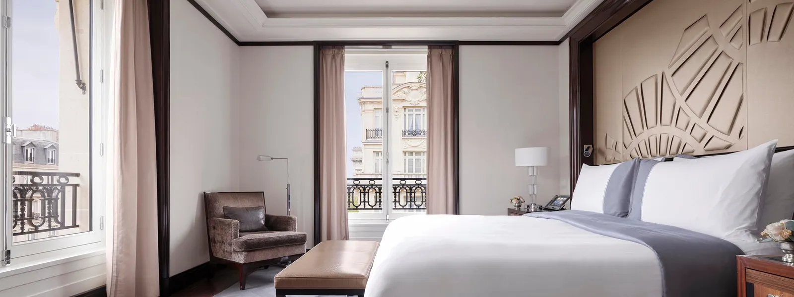 The Grand Premier Suite bedroom with a double bed and windows on 2 sides