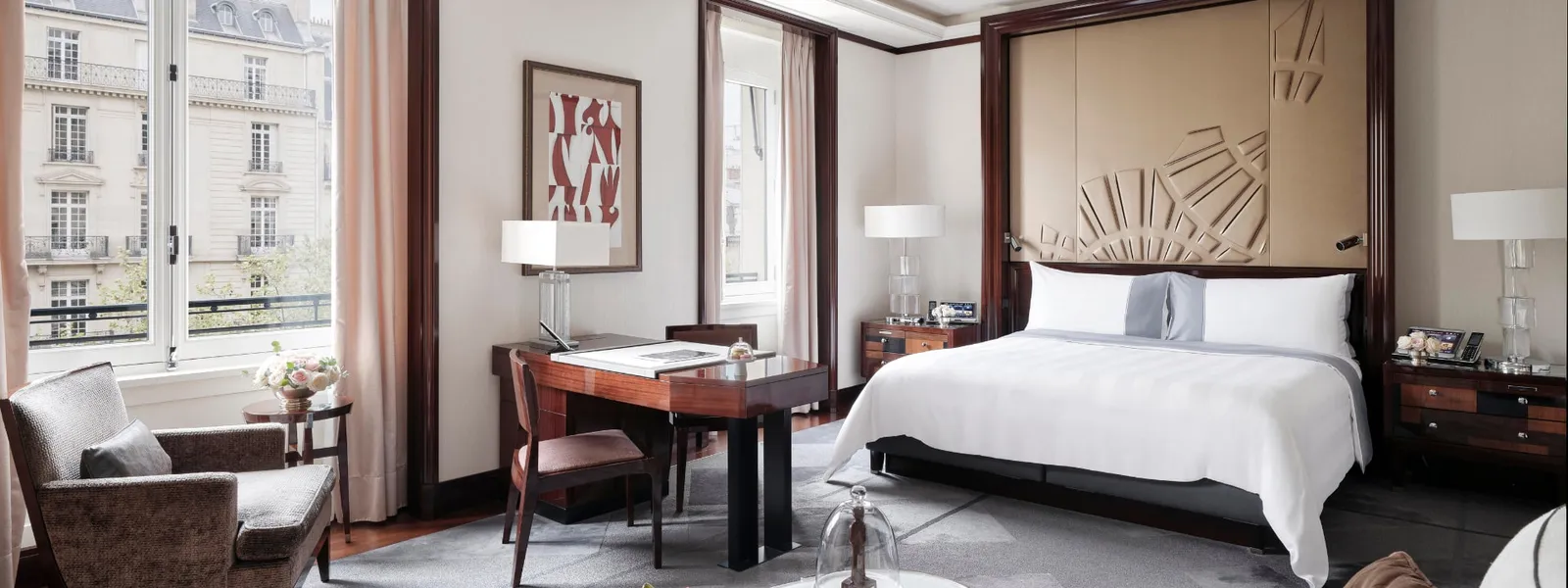 Junior Suite with a double bed, desk and armchair beside the window