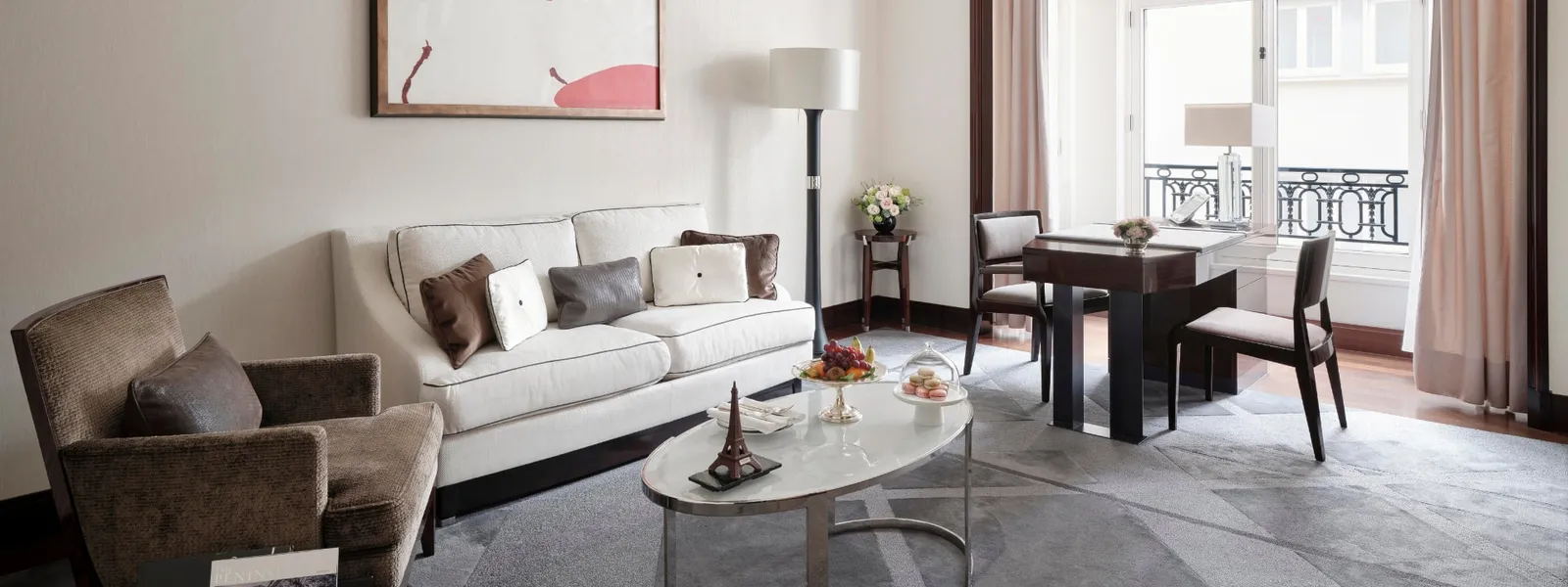 The Superior Suite living room with a sofa, armchairs and table beside the windows
