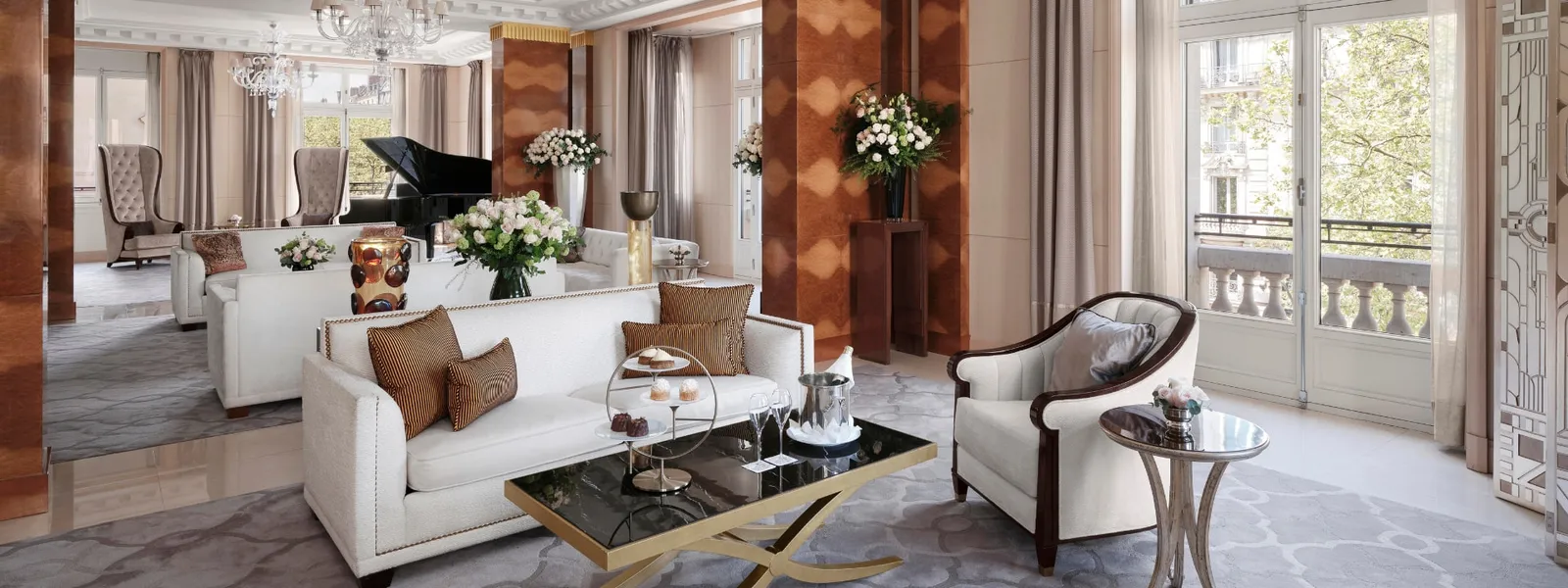 The Peninsula Suite living room with sofas, a piano and large windows