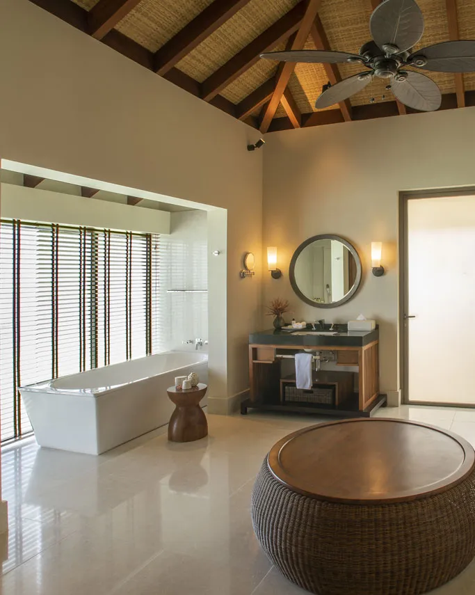 The villa bathroom, with a bath, washbasins and a timber roof
