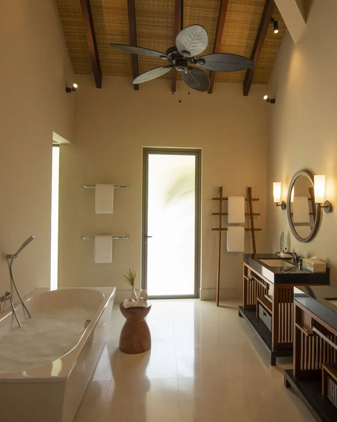 The villa bathroom, with a bath, washbasins and a timber roof