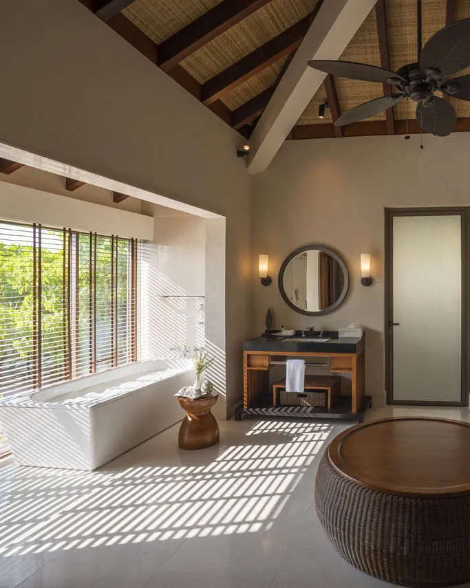 The villa bathroom, with a bath, washbasins and a timber roof