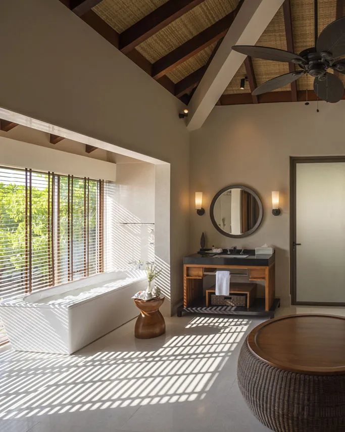 The villa bathroom, with a bath, washbasins and a timber roof