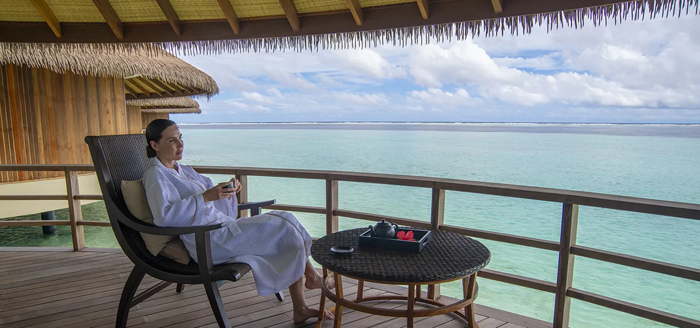 A guest on a shaded spa terrace overlooking the sea