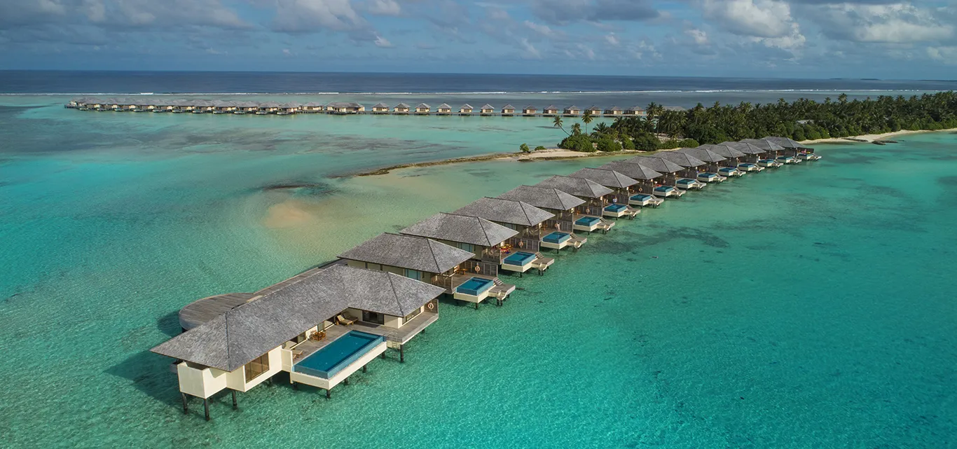 Water villas from above, along a curved walkway in the lagoon