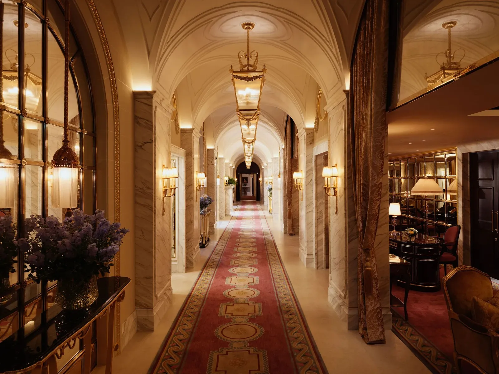 The Ritz’s Long Gallery: a corridor of lit arches, chandeliers and a red carpet running to the end