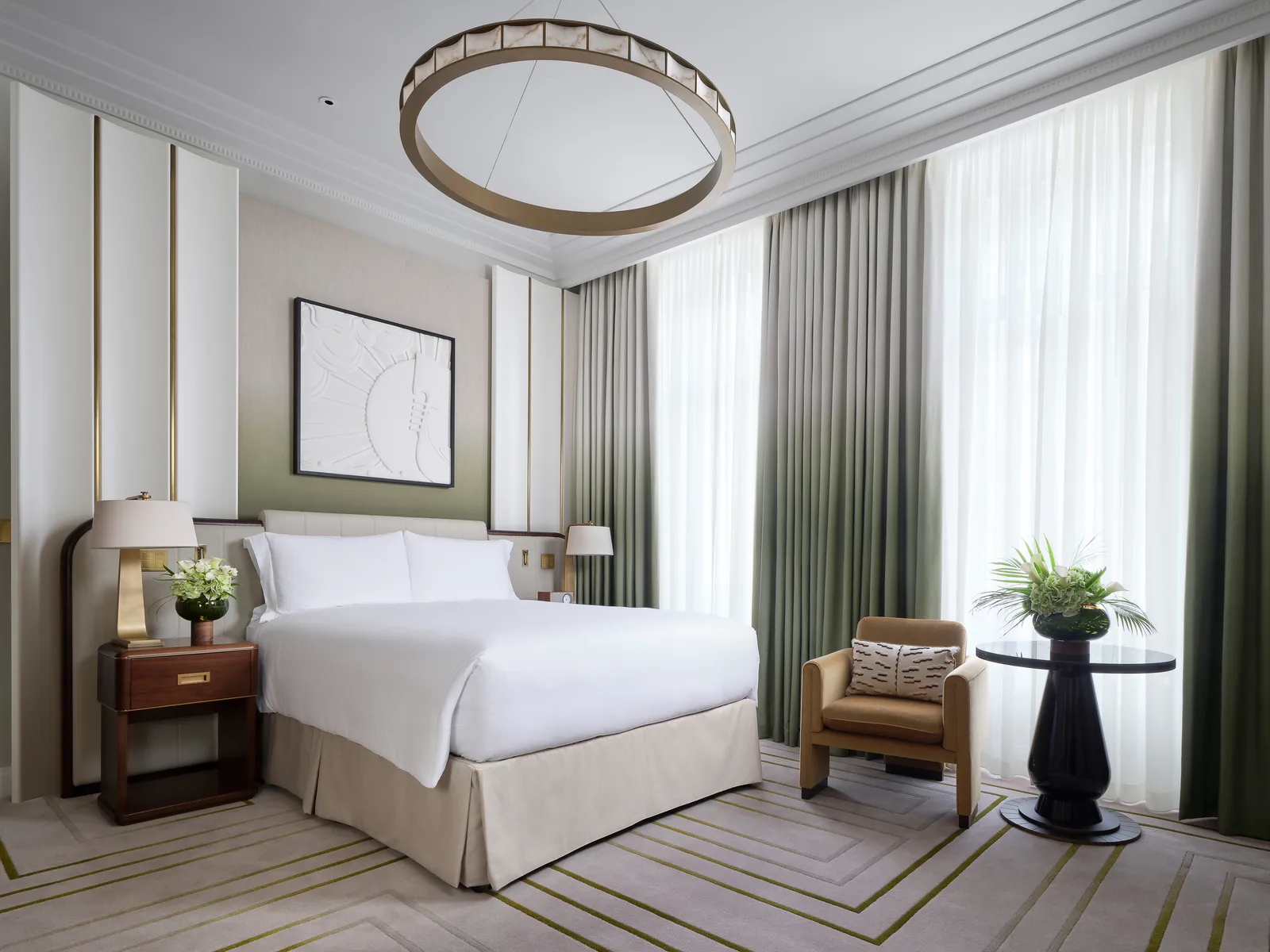 Deluxe King Room: a king bed, a ring chandelier and tall windows