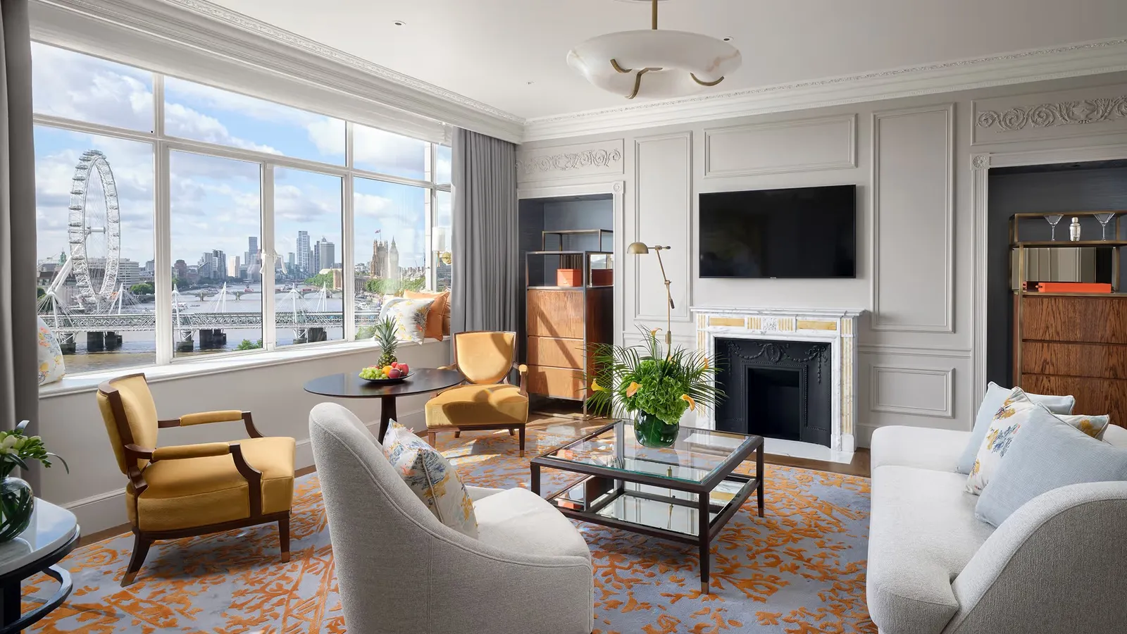 One Bedroom River View Suite: the living room with its fireplace and a window onto the Thames and the London Eye