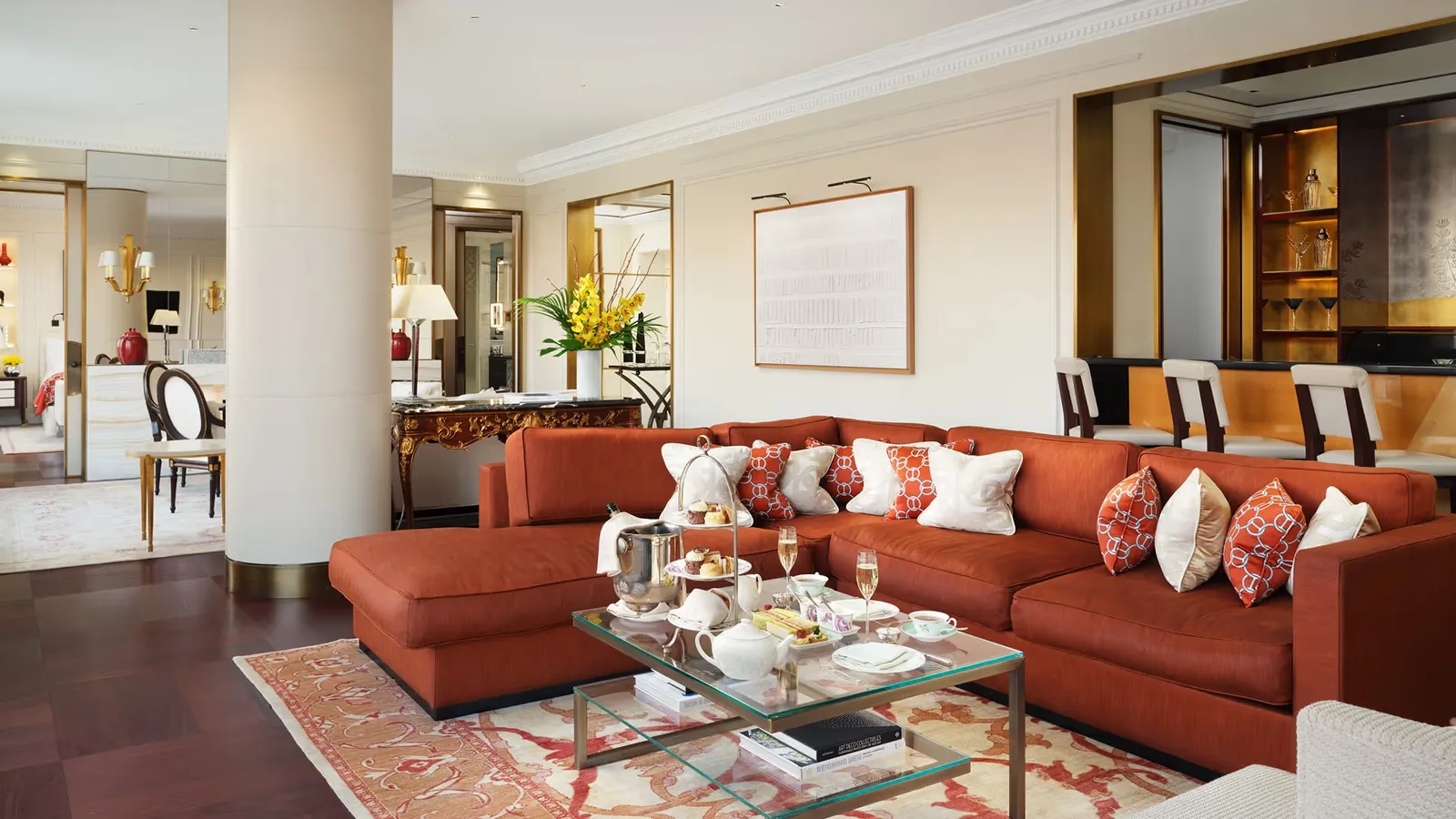 Savoy Suite: the living room with an orange sofa and the bar beyond