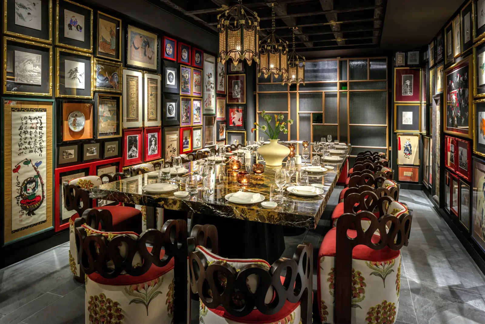 Japón’s Kyoto Room: a long dark marble table laid for dinner, upholstered chairs and walls covered in framed prints.