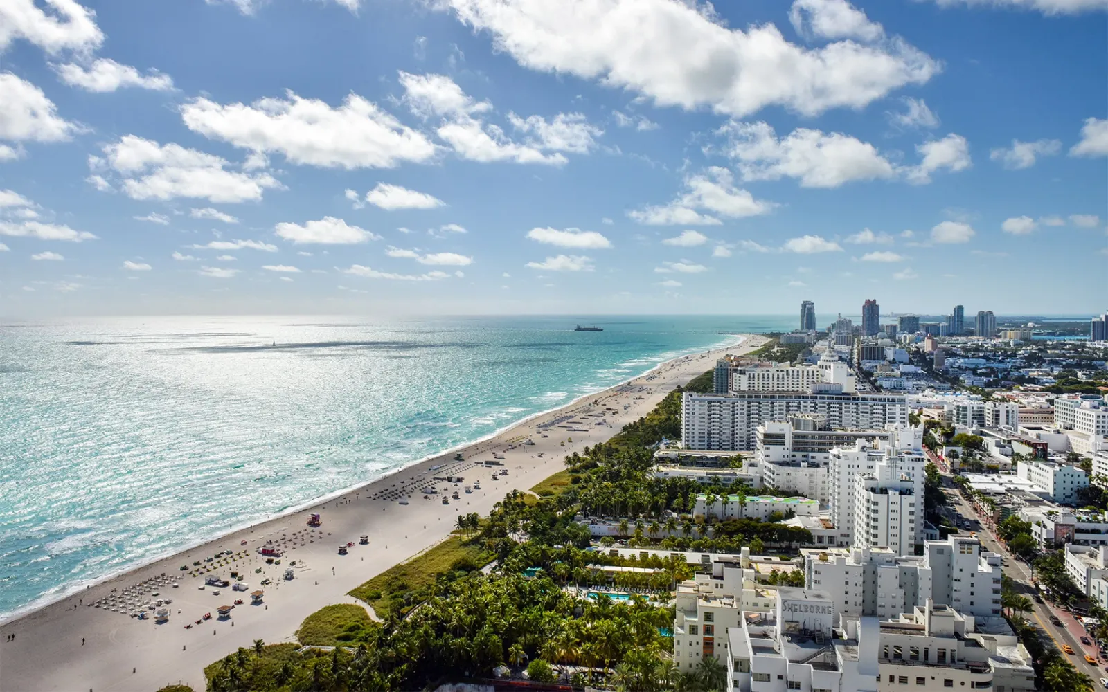 Miami Beach’s shore from above: the sand, the pale sea and South Beach’s white buildings to the horizon.