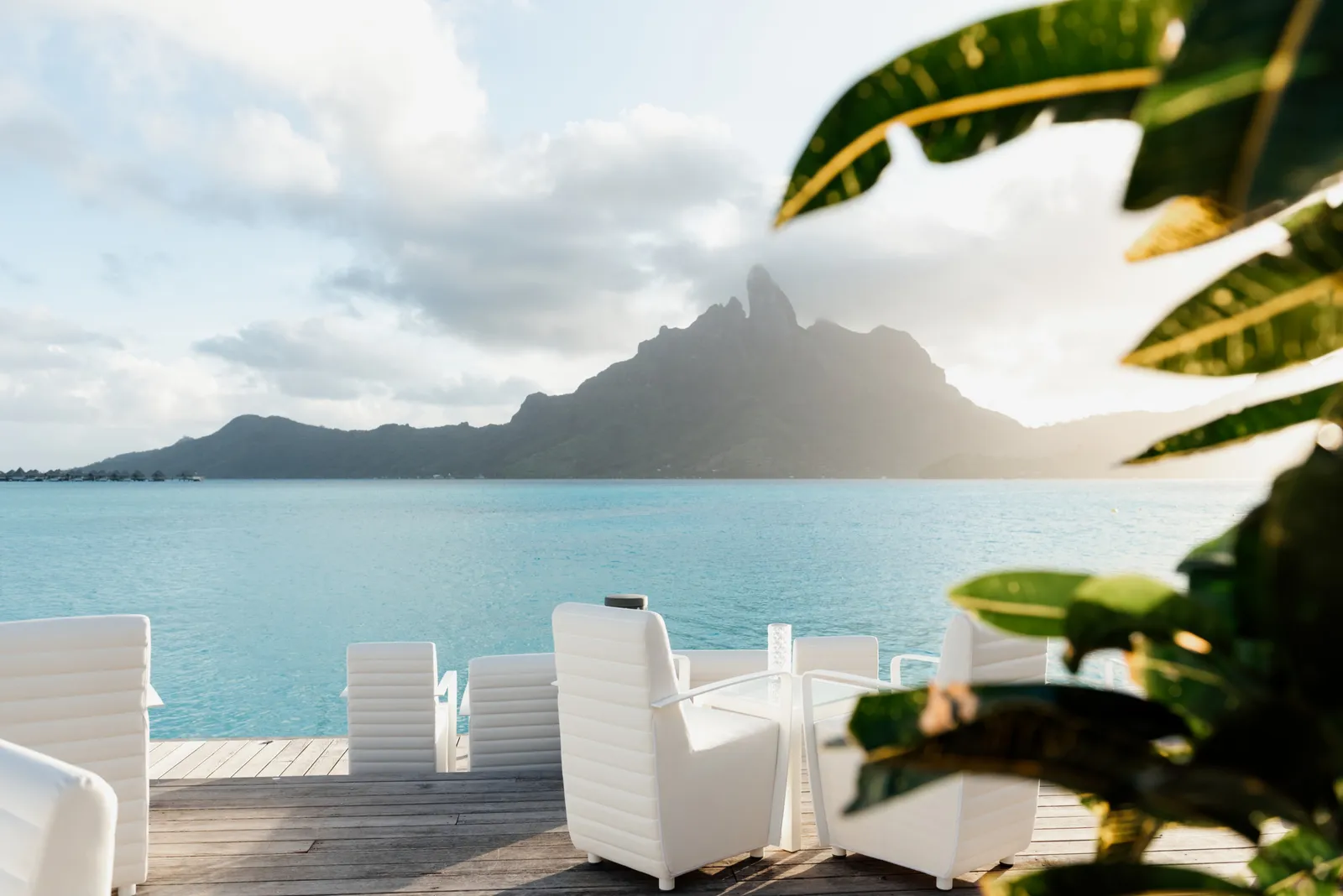 The 727 Bar deck at sunset, white armchairs facing the lagoon and Mount Otemanu