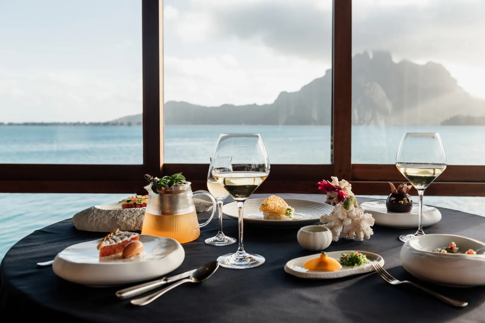 A table laid at Lagoon Restaurant, the window open on the water and Mount Otemanu