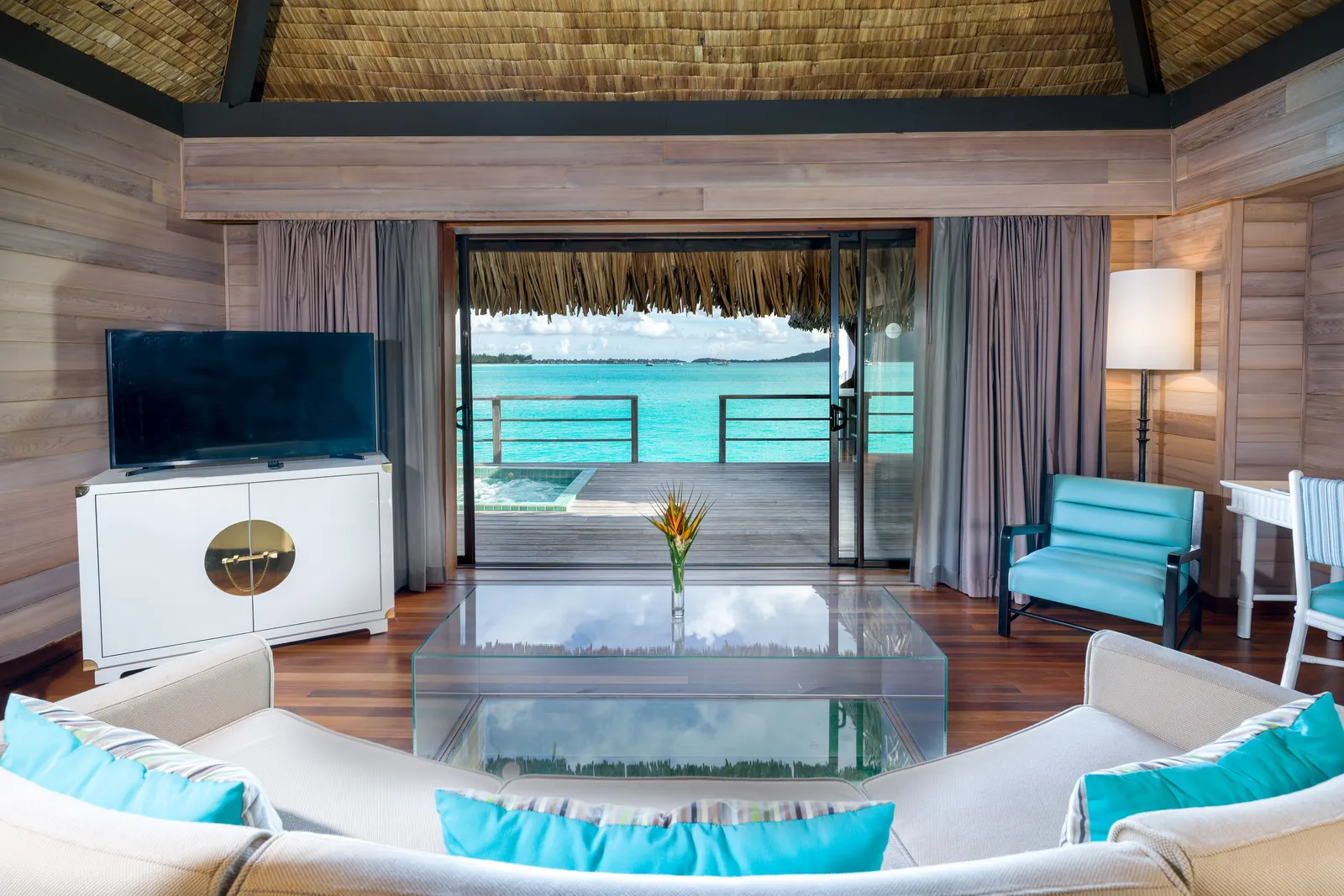 The sitting room opening on the deck, the whirlpool and the lagoon beyond