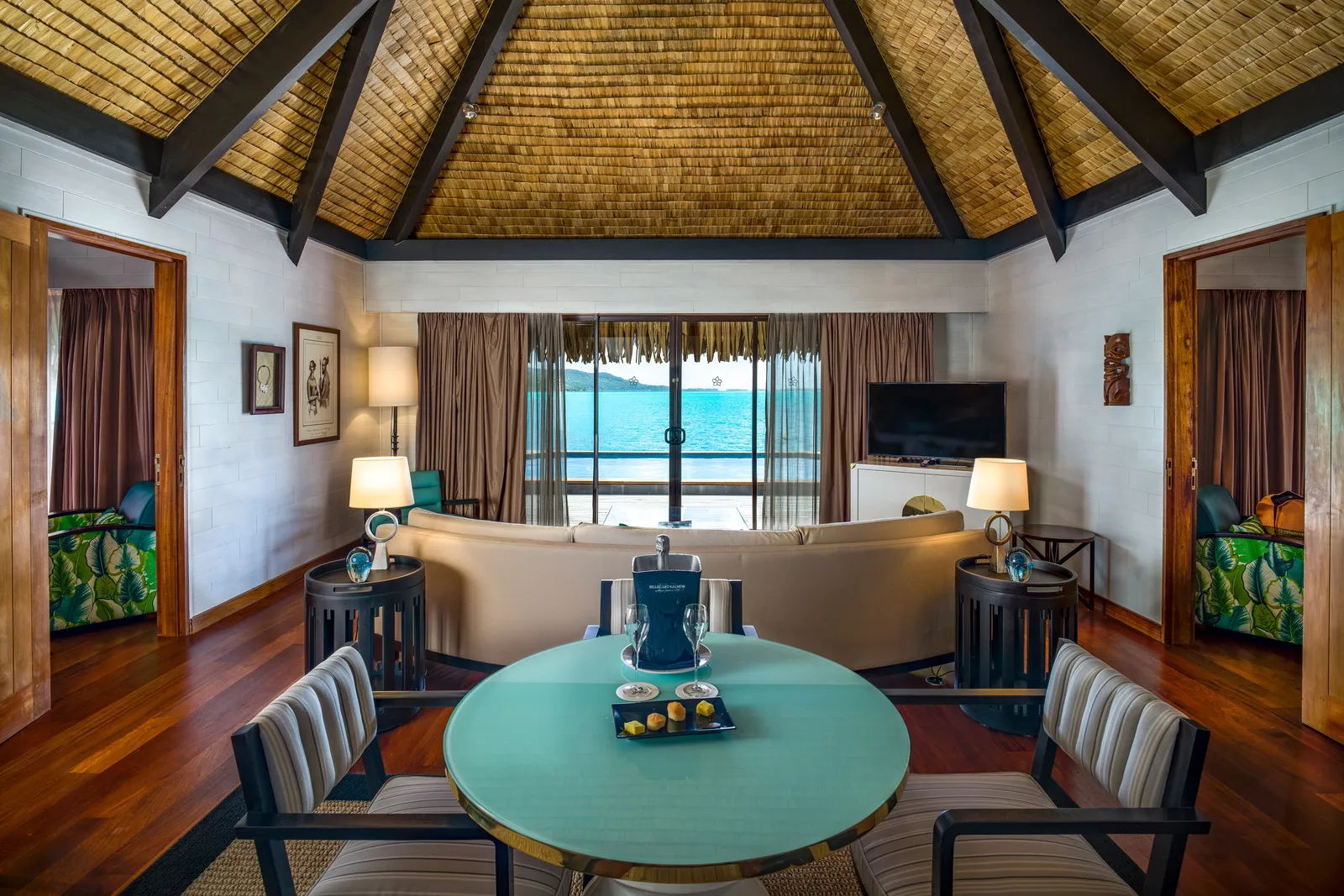The sitting room of a 2-bedroom Overwater Royal, a round table laid for breakfast