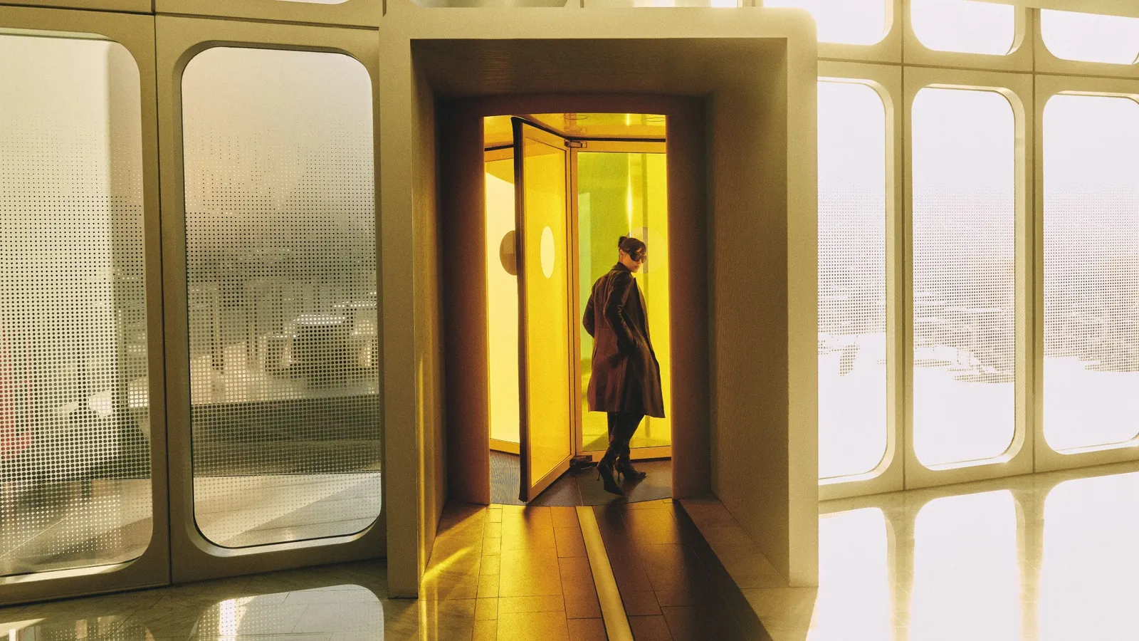 The entrance with its yellow revolving door behind curved glass