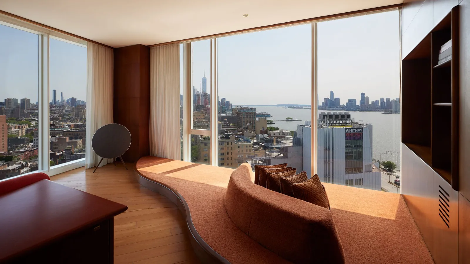 The Liberty Suite lounge, the curved leather sofa and the view of Lower Manhattan