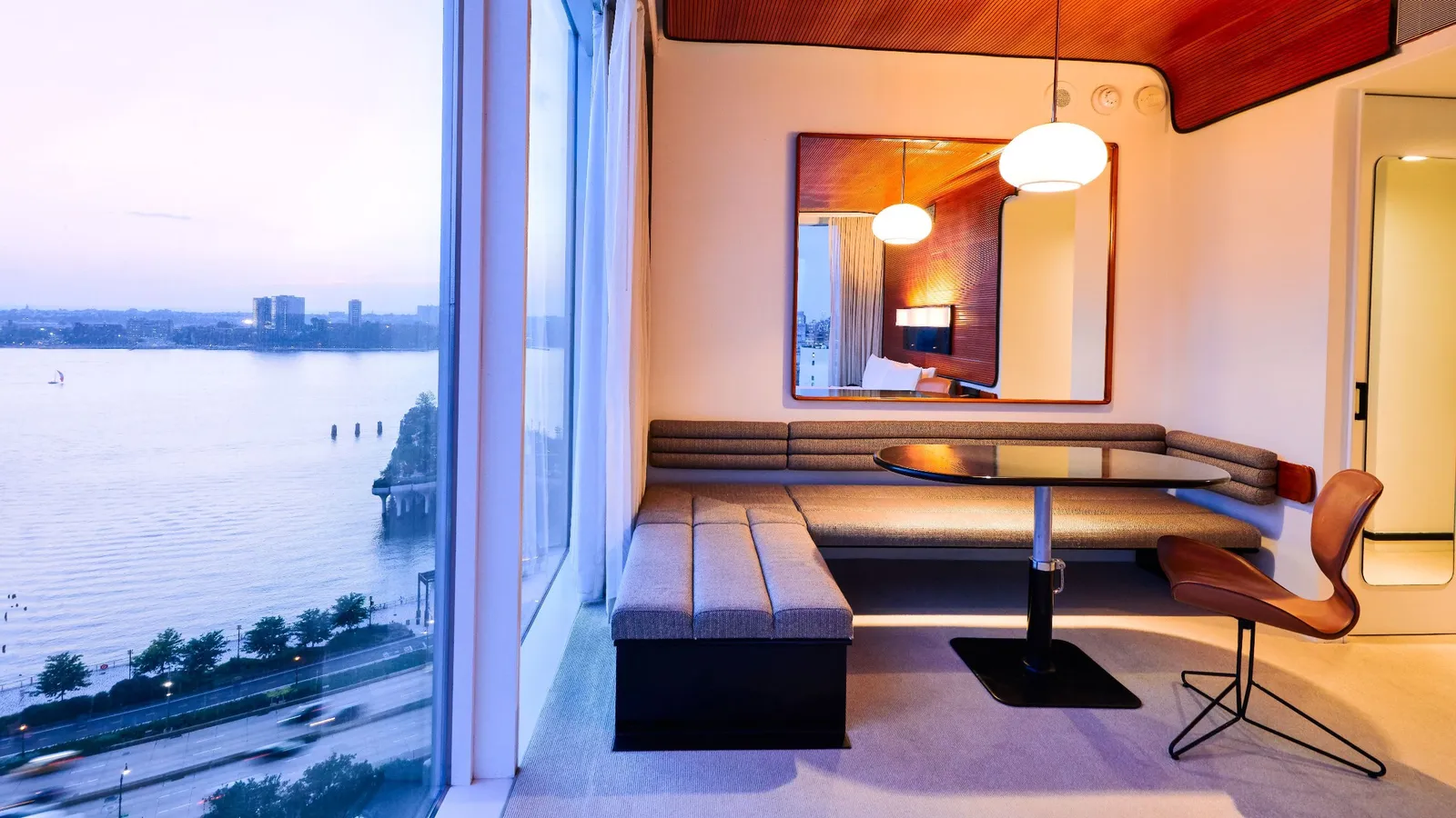 A corner room at the Standard at dusk, the Hudson beyond the glass