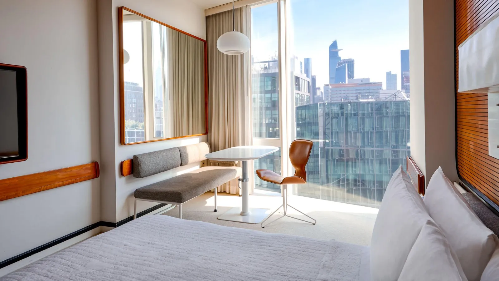 A Deluxe King with the bench under the glass wall and the Hudson Yards towers