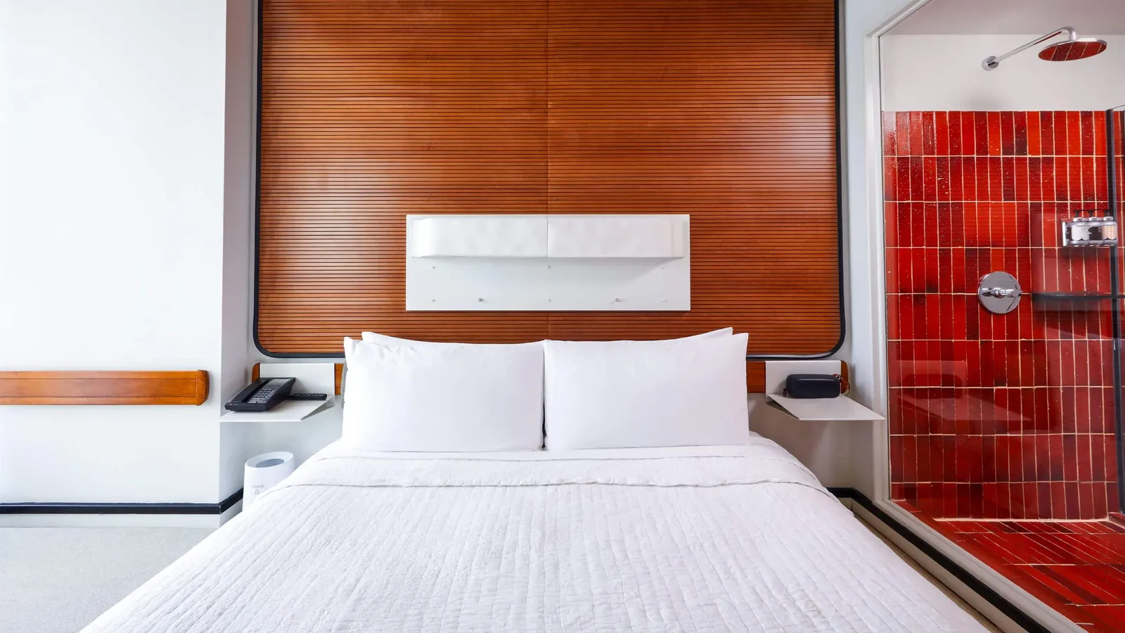 A Standard King with its timber headboard and the red-tiled shower in view