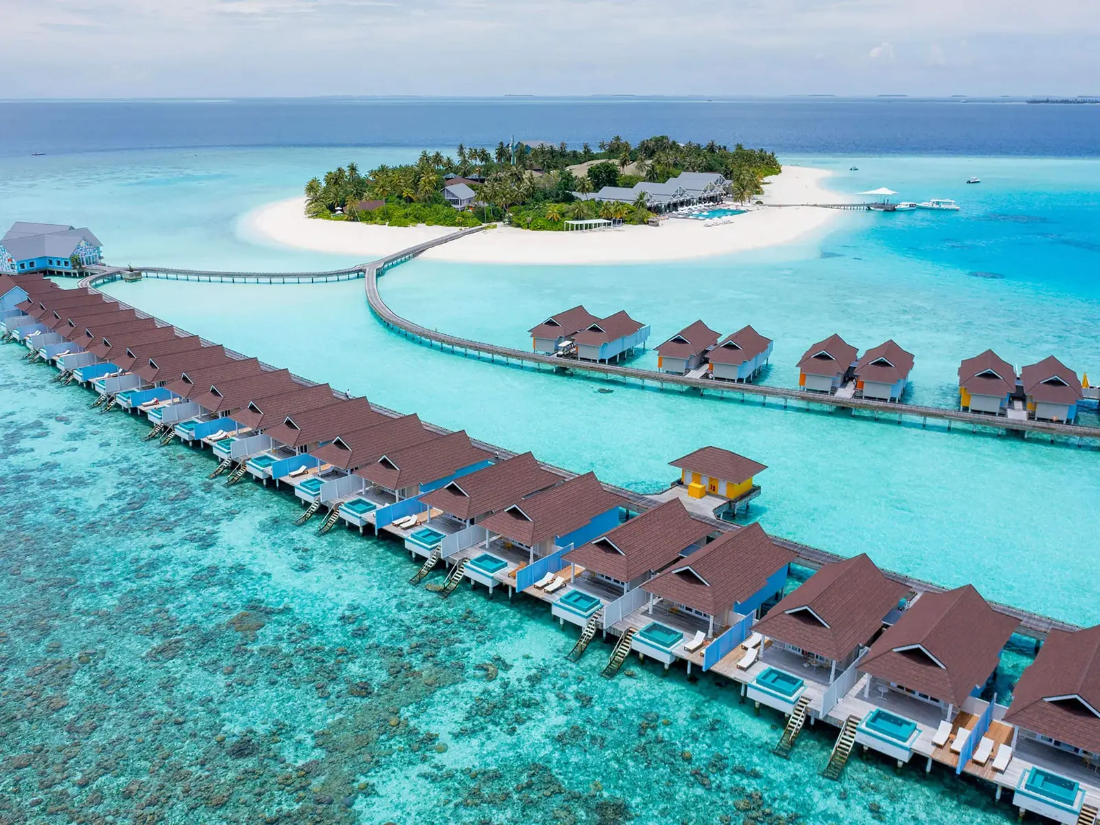 Huruvalhi from above: the island and its spit of sand, the jetties and the rows of water villas in the lagoon.