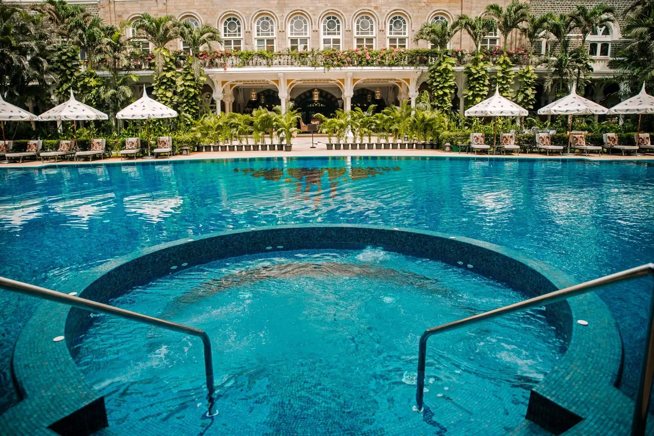 La piscina nel cortile, con la vasca idromassaggio e la facciata coperta di verde