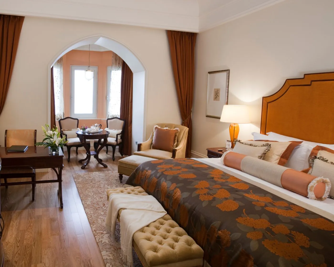 Una Taj Club Room con testiera arancio e salottino davanti alla finestra