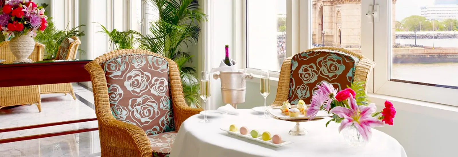 Un tavolo apparecchiato con dolci e fiori accanto alle finestre del Sea Lounge