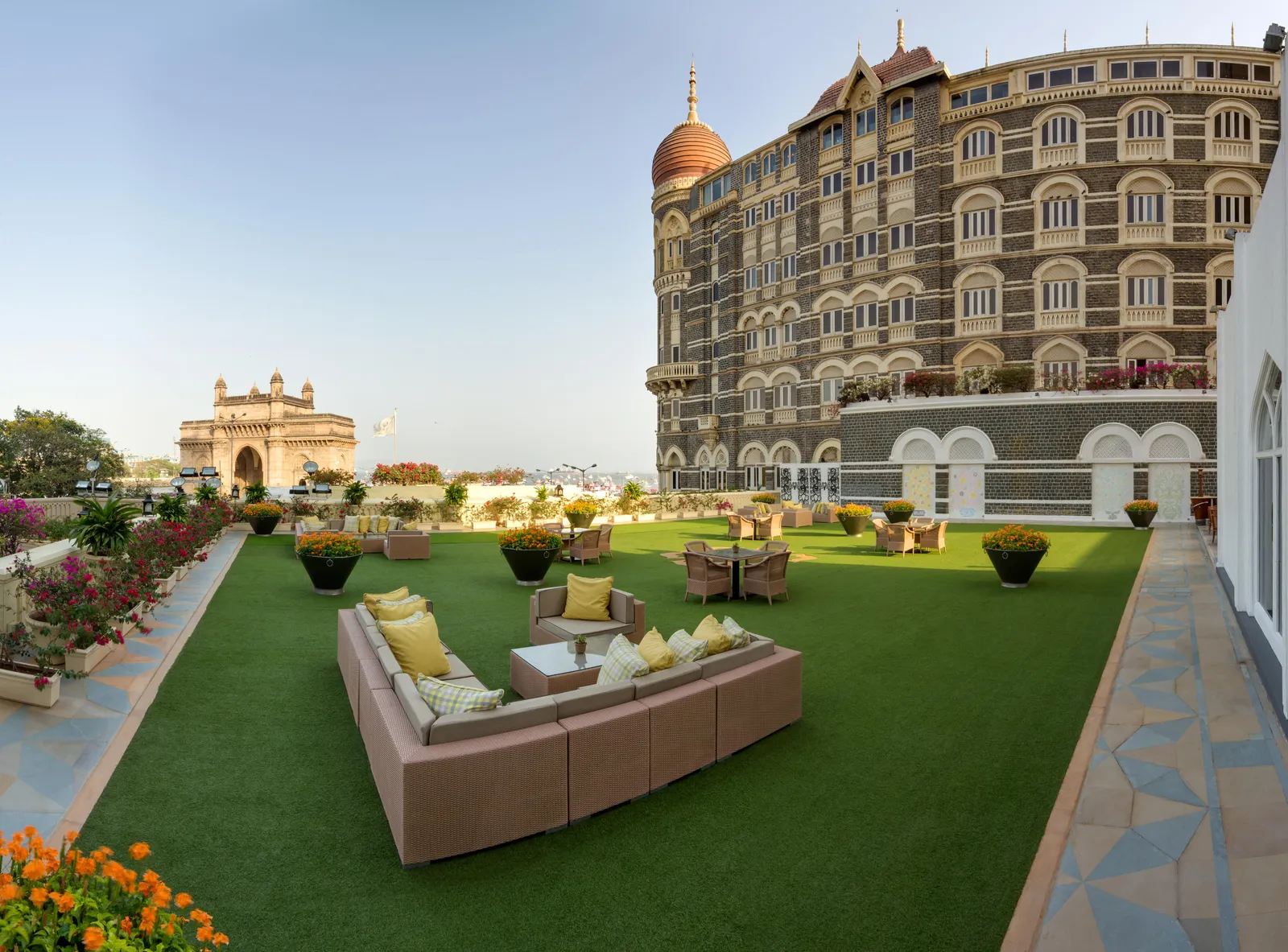 Il prato sulla terrazza con i divani, il Gateway of India e il porto sullo sfondo
