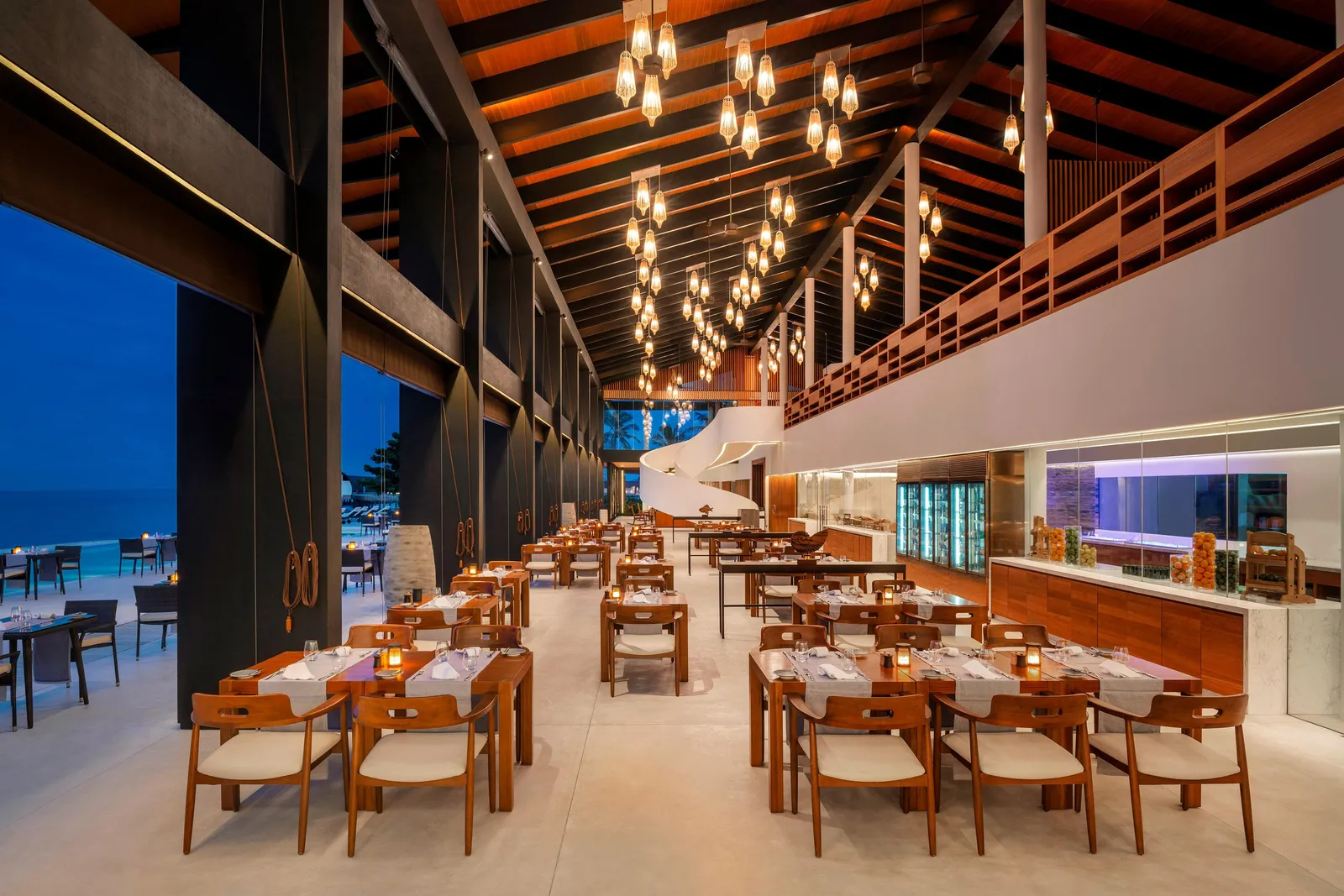 Island Kitchen’s dining room, with its high timber ceiling, hanging lamps and laid tables open to the sea.