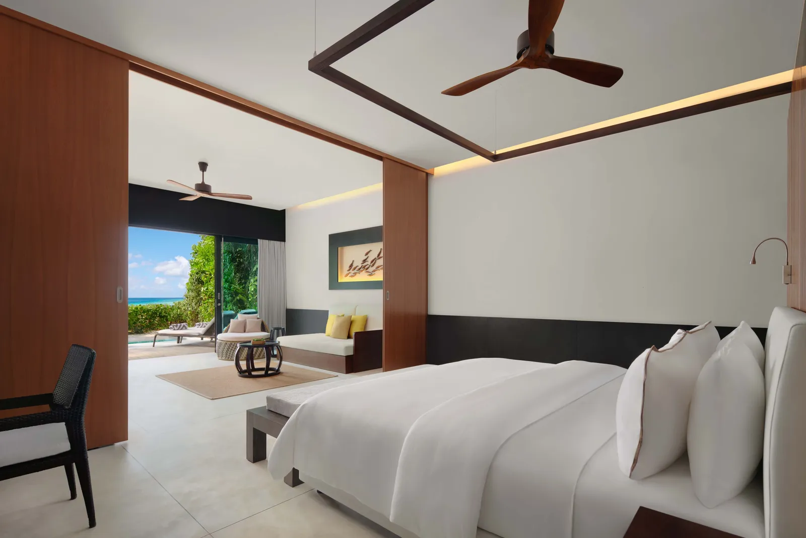 The Deluxe Beach Villa Pool: the king bed facing the sliding wall that opens to the sitting room and the deck.