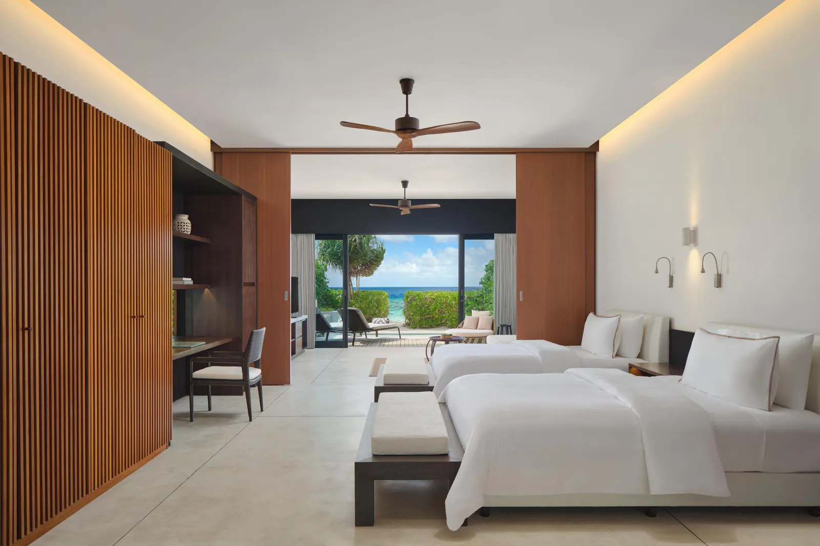 The Family Deluxe Beach Villa, with 2 double beds, the timber wall and the view over the garden and the sea.