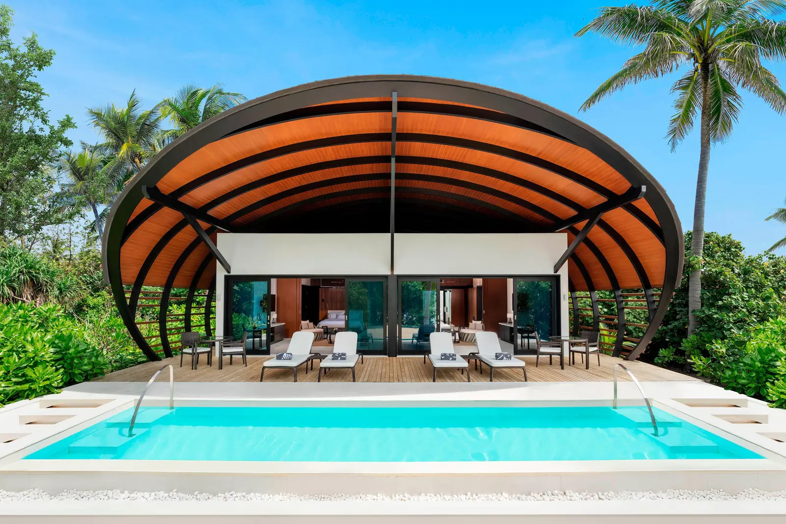 The Two Bedroom Villa – Pool under its curved turtle-shell roof, with the pool in front and loungers on the deck.