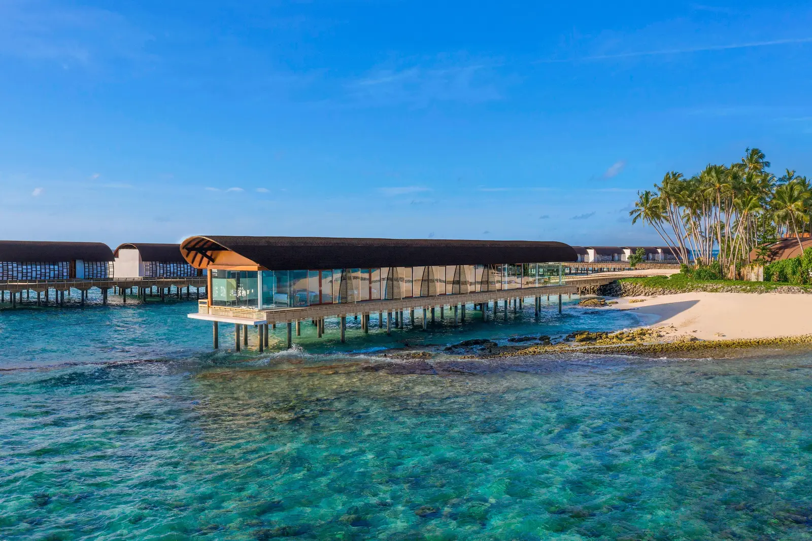The Heavenly Spa on stilts above the reef, a glass pavilion joined to the island by a walkway.