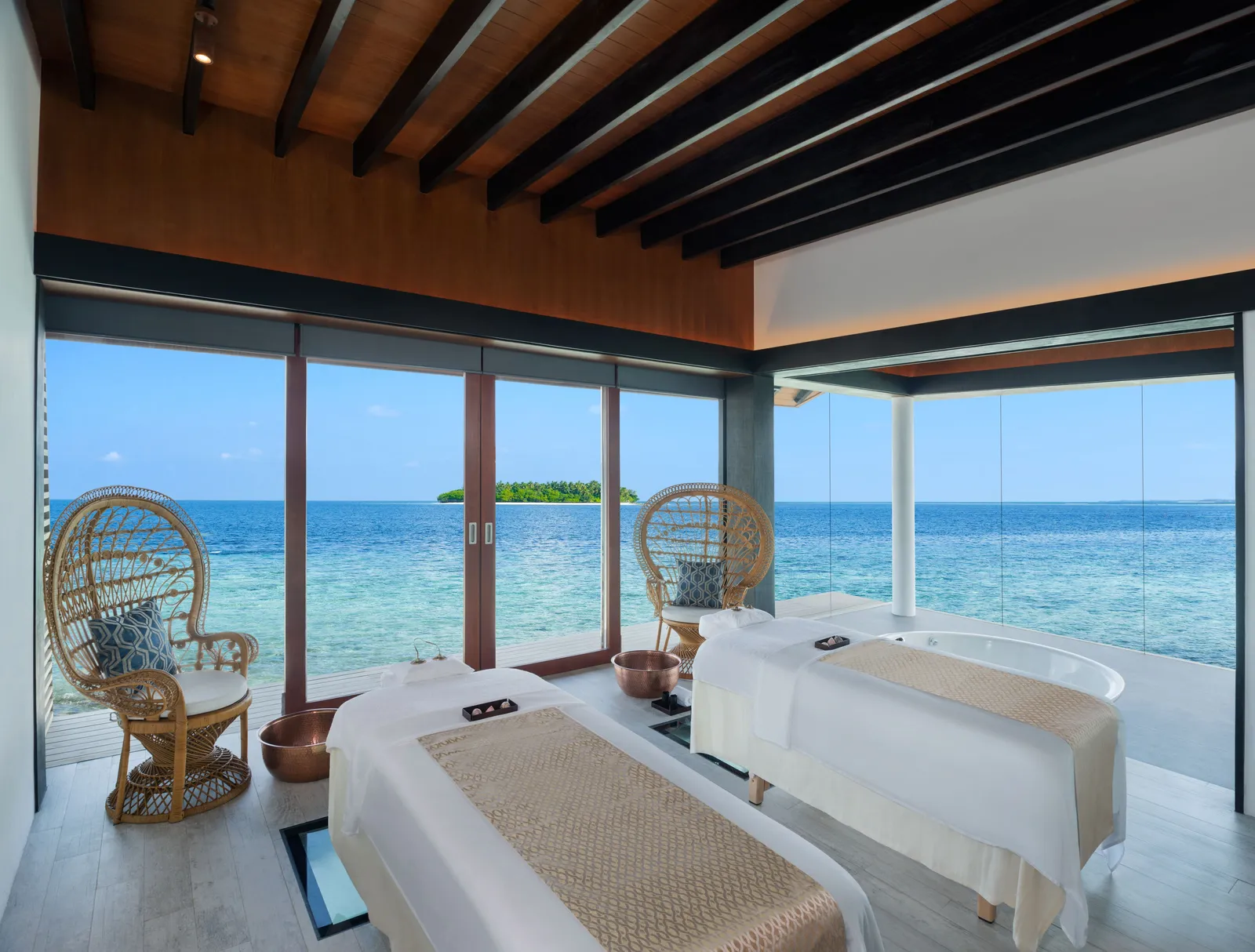 The spa’s couples’ suite: 2 treatment beds facing the glass on the ocean, the bath and a glass panel in the floor.