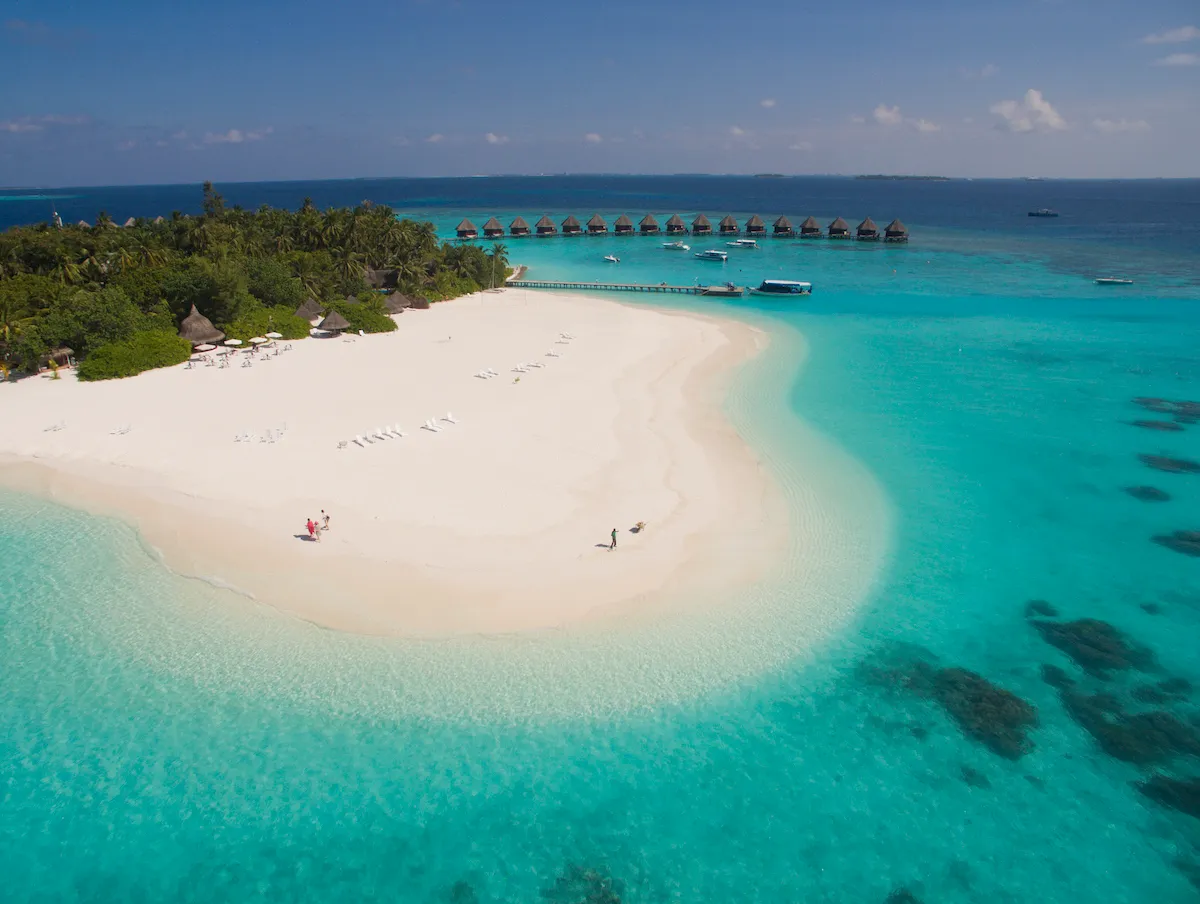 The island’s white sandspit running into the turquoise lagoon, with the water bungalows in the distance.