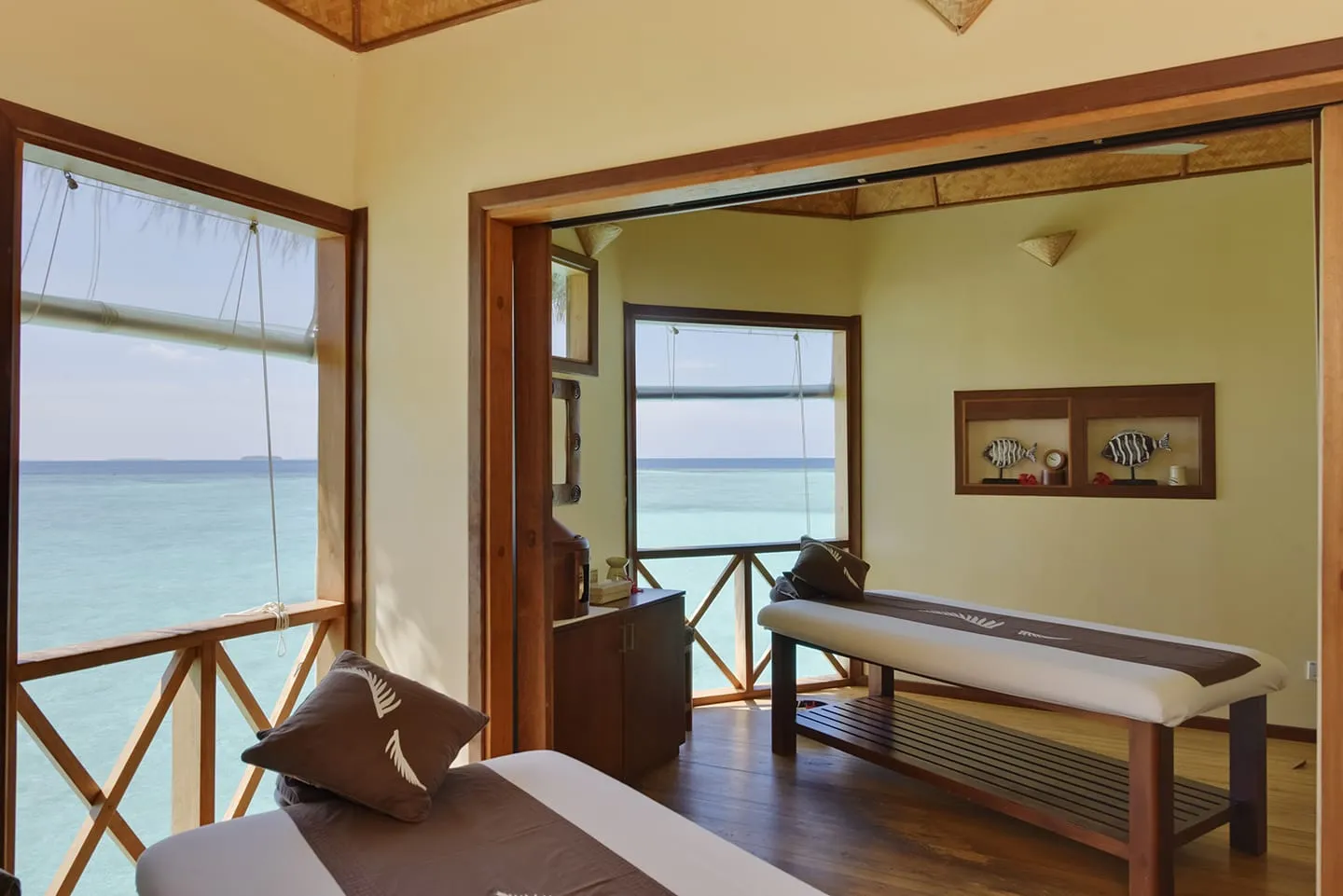A treatment room of the spa over the water, with the massage bed and windows onto the sea.