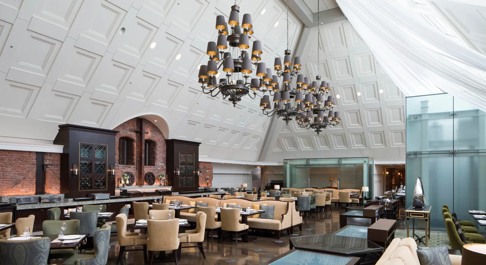 The Atrium under the station roof: the white gabled ceiling, 2 chandeliers, the original brick wall and the breakfast tables.