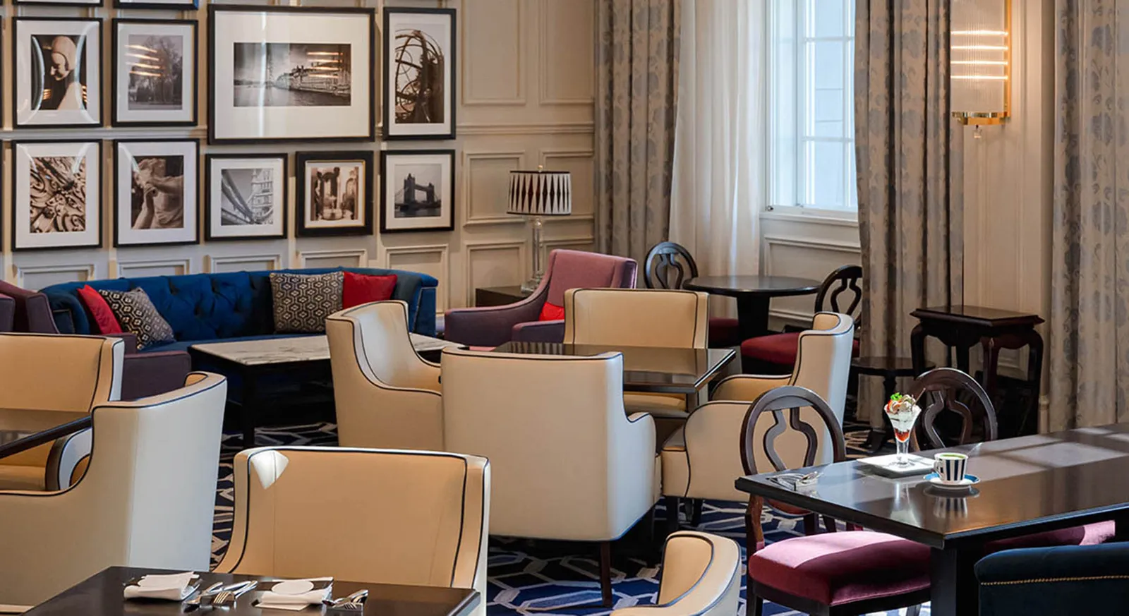 The Lobby Lounge: white armchairs and a blue sofa under a wall of black-and-white photographs.